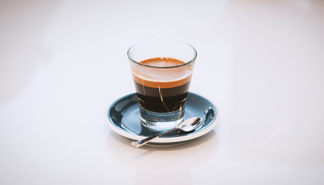 Espresso im Glas mit Untertasse und Löffel